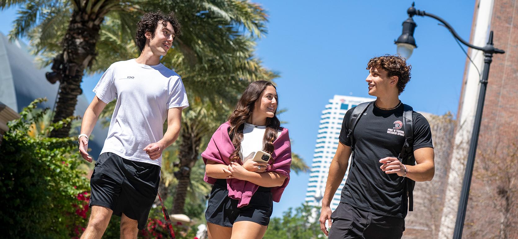 students walking on campus with downtown Tampa skyline in background